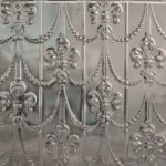 A ceiling with a silver floral and beads pattern