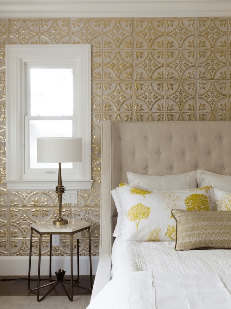 A bedroom with golden wallpaper and a bed