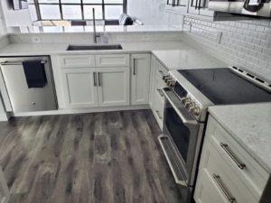 A corner of a kitchen with grey cabinets