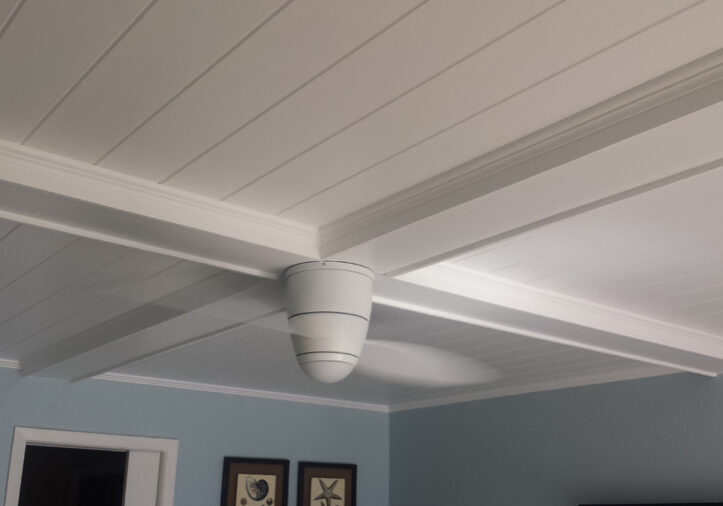 A room with a fan and a white ceiling and blue walls