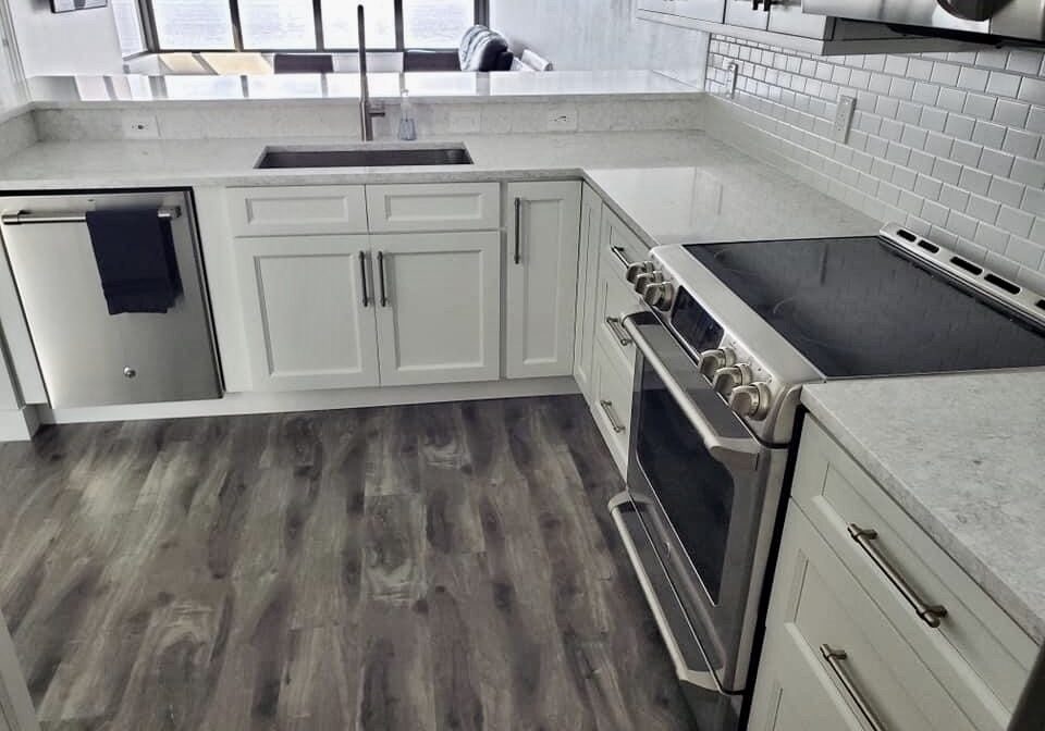 A corner of a kitchen with grey cabinets